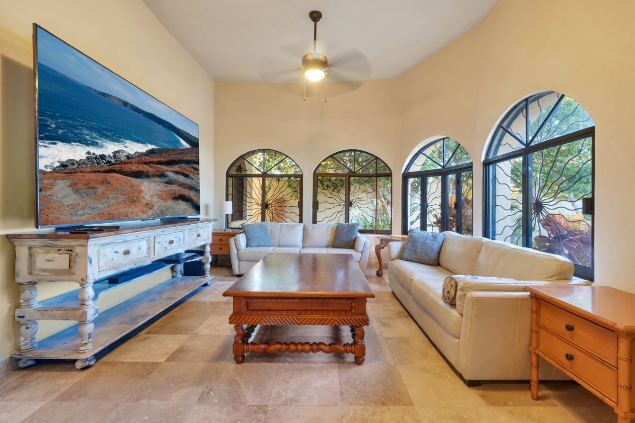 Living room with white leather couches and large television